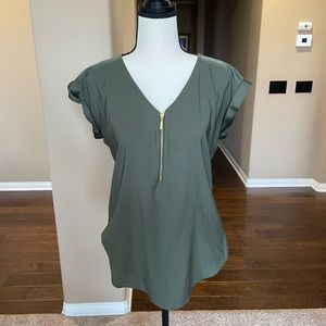 Green short sleeve blouse with gold zipper down the front.